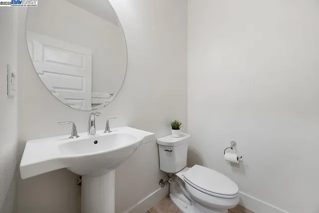 a bathroom with a sink a toilet and a mirror