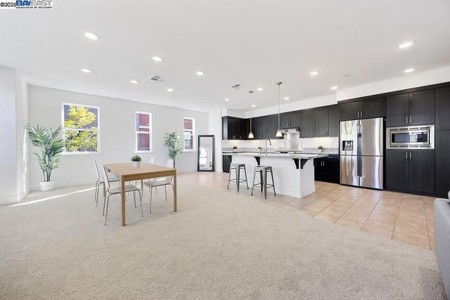 a large kitchen with stainless steel appliances a white stove top oven a white table and chairs