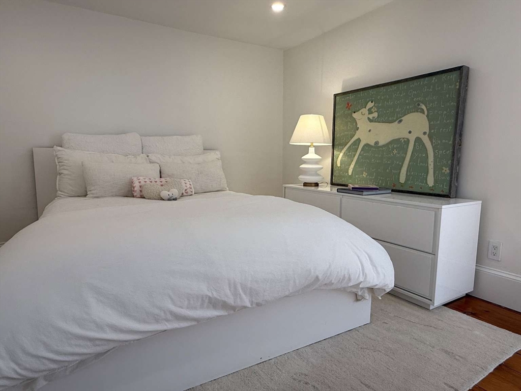 105 Elm Street, Unit A Andover, MA 01810 - Photo 31 of 40 a bedroom with a bed and a painting on the wall