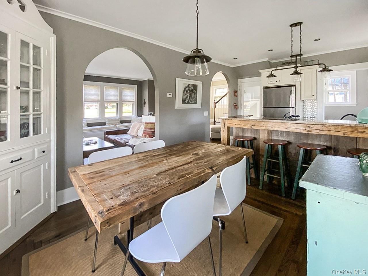 2490 Pike Street Mattituck, NY 11952 - Photo 6 of 15 Dining area featuring ornamental molding, arched walkways, and dark wood-style floors