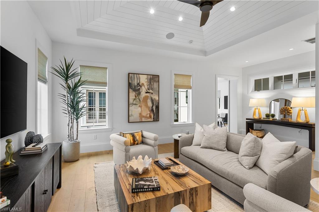 835 11th Avenue South Naples, FL 34102 - Photo 23 of 31 a living room with furniture a flat screen tv and a large window