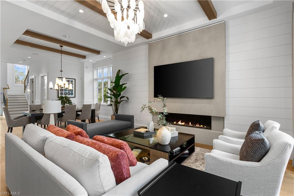 835 11th Avenue South Naples, FL 34102 - Photo 6 of 31 a living room with furniture a fireplace and a flat screen tv