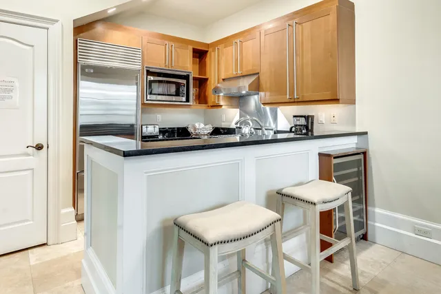 a kitchen with stainless steel appliances granite countertop a stove a sink refrigerator and microwave
