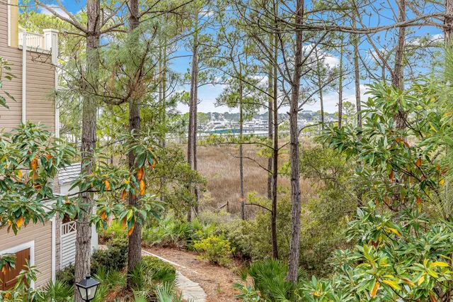 a bedroom with a large bed a flat tv screen and a dresser next to a window