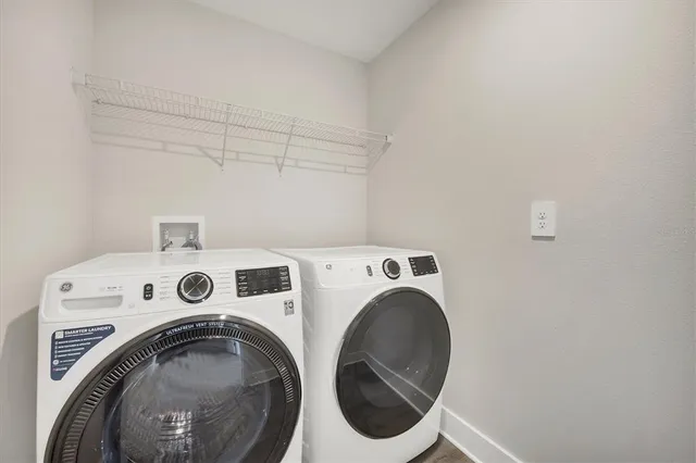 a sign board with tall yellow house in the background