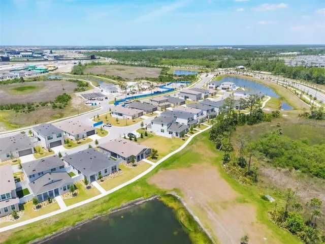 an aerial view of ocean and residential houses with outdoor space