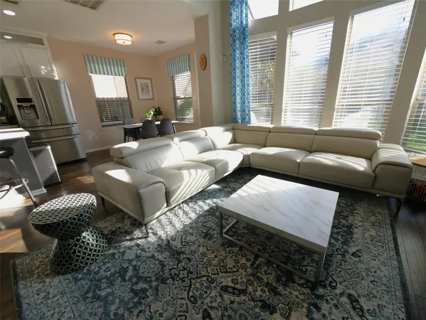 a living room with furniture wooden floor and a large window