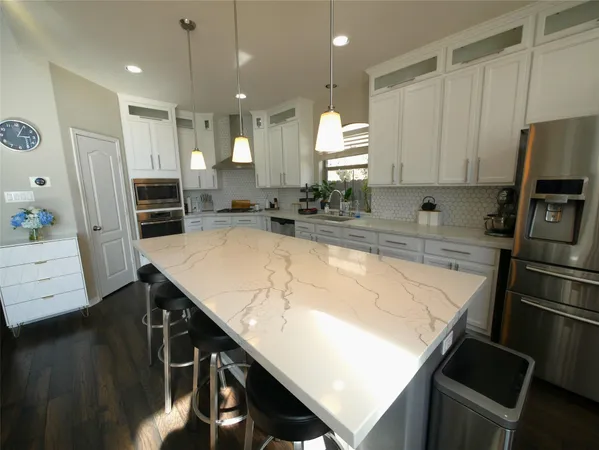 a kitchen with kitchen island a counter top space cabinets and stainless steel appliances