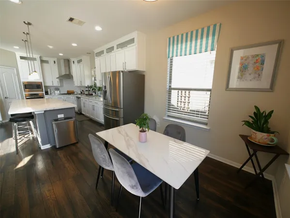 a kitchen with a table chairs refrigerator and microwave