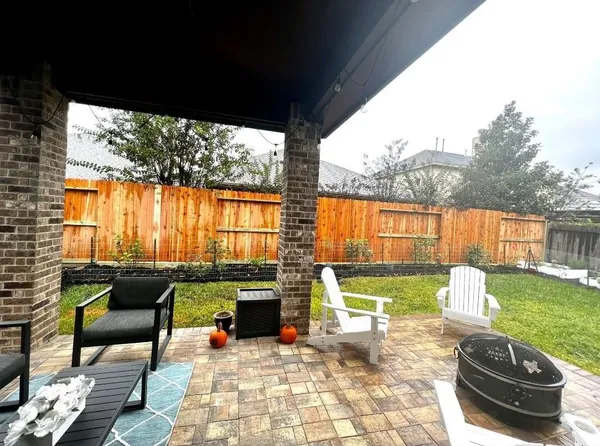 a living room with patio furniture and a garden