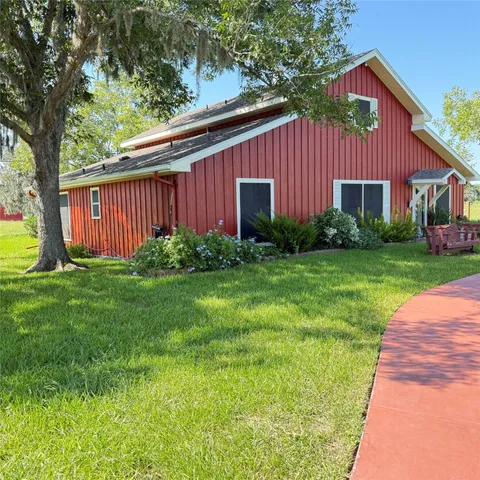 a view of a backyard with plants and large trees