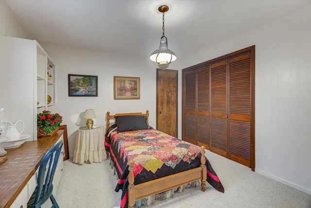 a view of swimming pool in front of house with trees all around