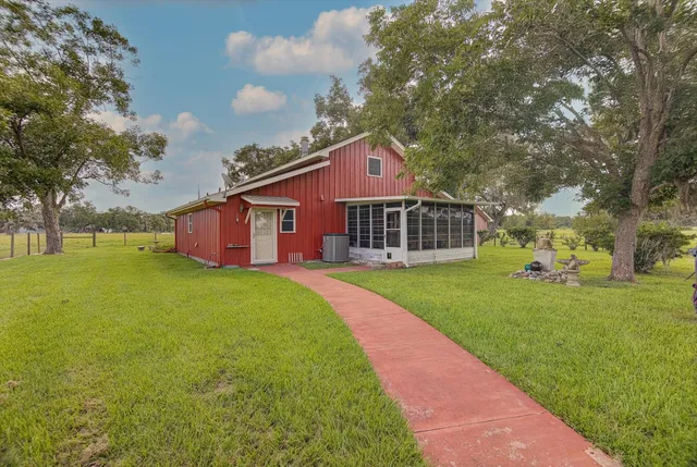 a view of a lake with a yard and large trees
