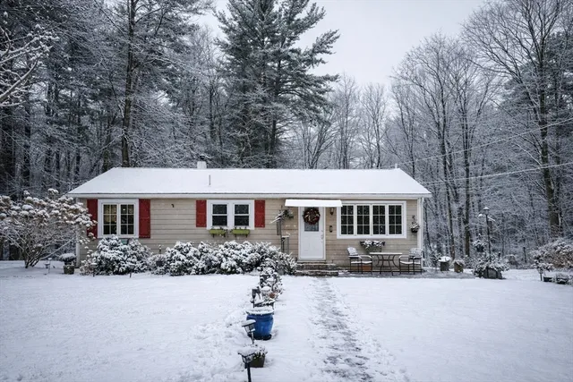 a front view of a house with yard and trees around