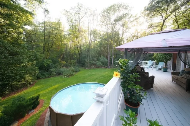 a view of backyard with seating space and wooden fence