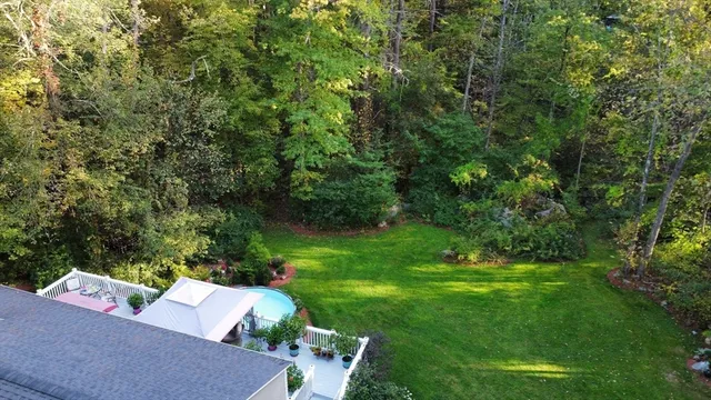 a view of a backyard with couches under an umbrella
