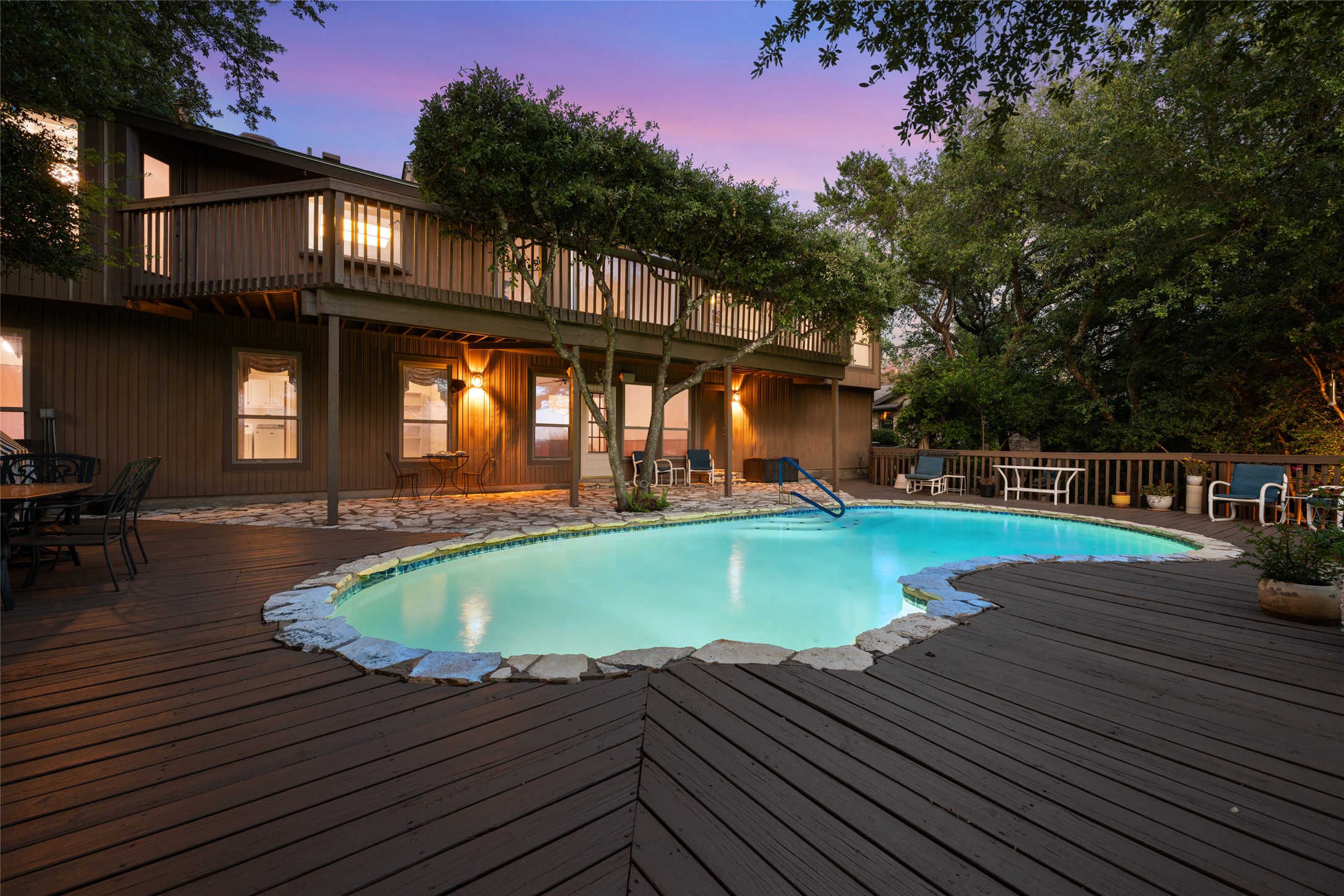 5319 Musket Ridge Austin, TX 78759 - Photo 36 of 39 An inviting backyard oasis features a freeform pool surrounded by a spacious wood deck, perfect for twilight gatherings.
