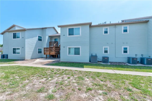 a view of a house with a yard and a large tree