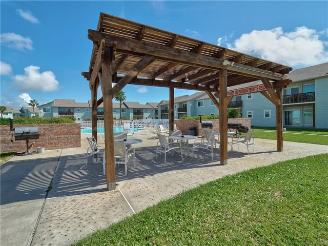 a view of a patio with a table and chairs under an umbrella
