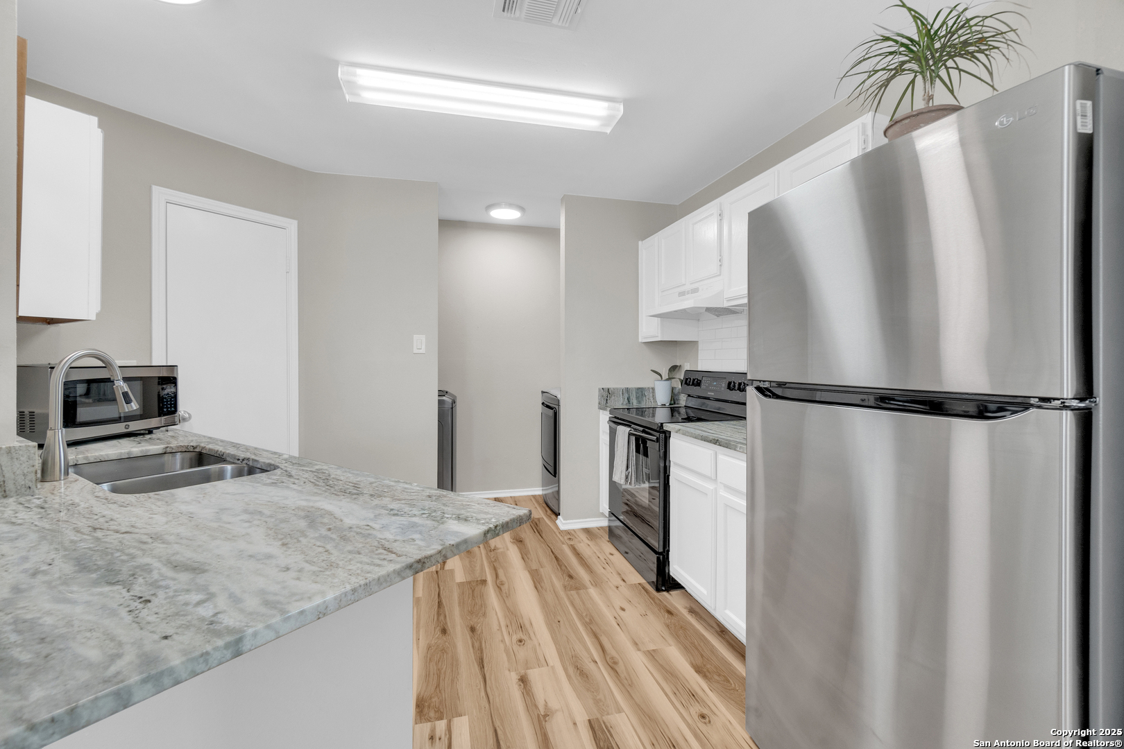 8722 Ridge Moon Drive San Antonio, TX 78239 - Photo 6 of 19 a kitchen with granite countertop a refrigerator and a sink