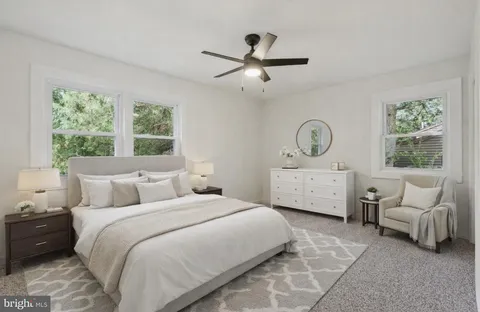 a bedroom with a bed a couch and window