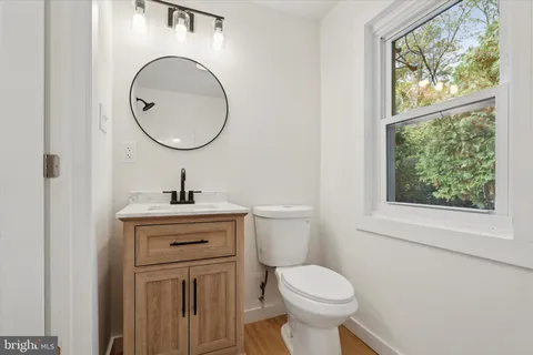 a bathroom with a toilet a sink and a mirror