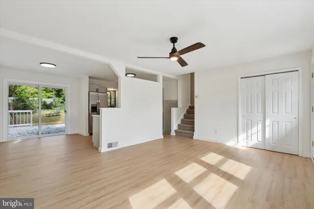 a view of a livingroom with wooden floor and a ceiling fan