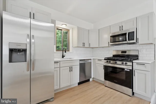 a kitchen with cabinets stainless steel appliances and a sink