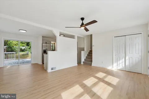 a view of a livingroom with wooden floor and a ceiling fan