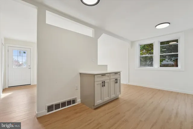 a hall with wooden floor and a window