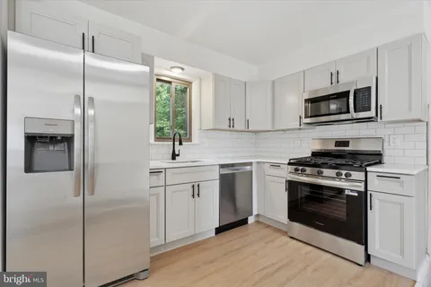 a kitchen with cabinets stainless steel appliances and a sink