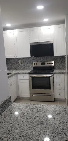 a stove top oven sitting inside of a kitchen