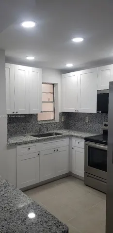 a kitchen with granite countertop cabinets stainless steel appliances and a sink