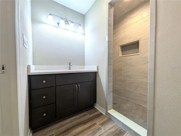a bathroom with a sink a mirror and shower