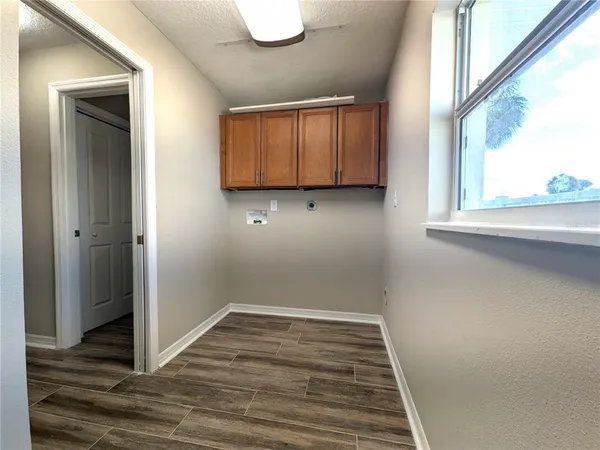 a view of a utility room with wooden floor and a window