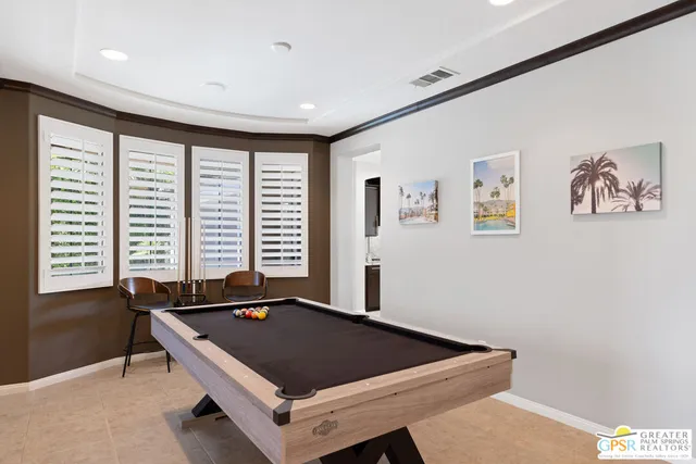 a room with pool table and windows