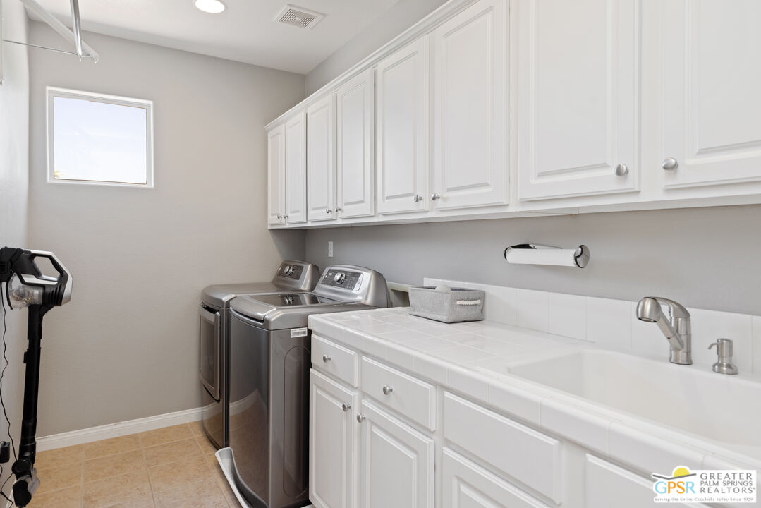80592 Apricot Lane Indio, CA 92201 - Photo 35 of 45 a kitchen with stainless steel appliances granite countertop a sink a refrigerator and white cabinets