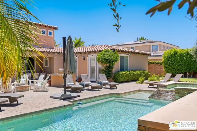 a view of a house with backyard and sitting area