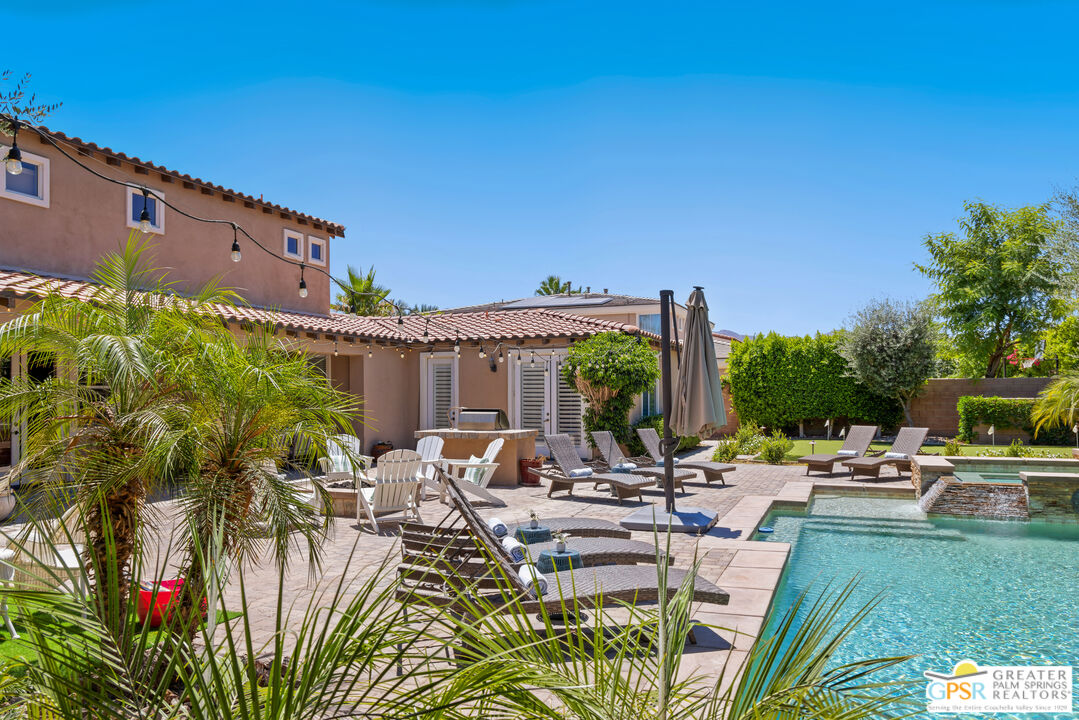 80592 Apricot Lane Indio, CA 92201 - Photo 41 of 45 a view of a patio with couches table and chairs under an umbrella with potted plants
