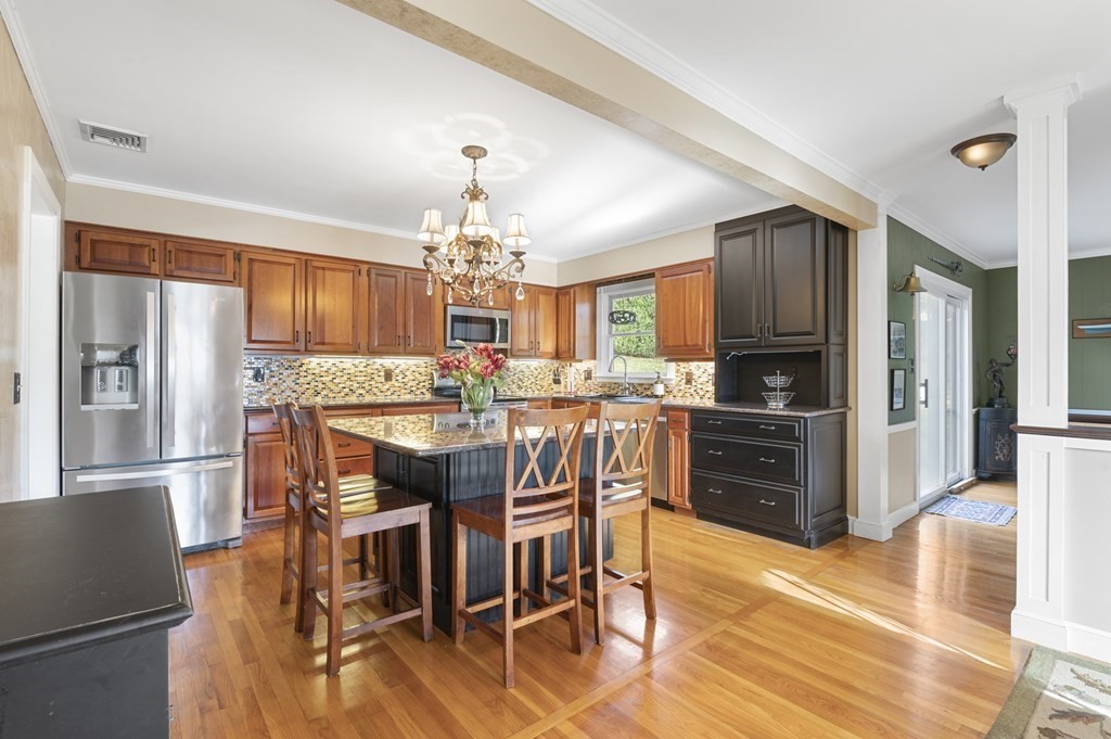 5 Colgate Road Marblehead, MA 01945 - Photo 12 of 36 a kitchen with stainless steel appliances kitchen island granite countertop a refrigerator a stove a sink a dining table and chairs with wooden floor