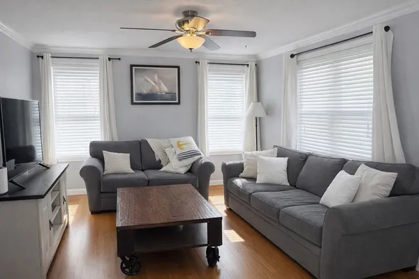 a living room with furniture a flat screen tv and a large window