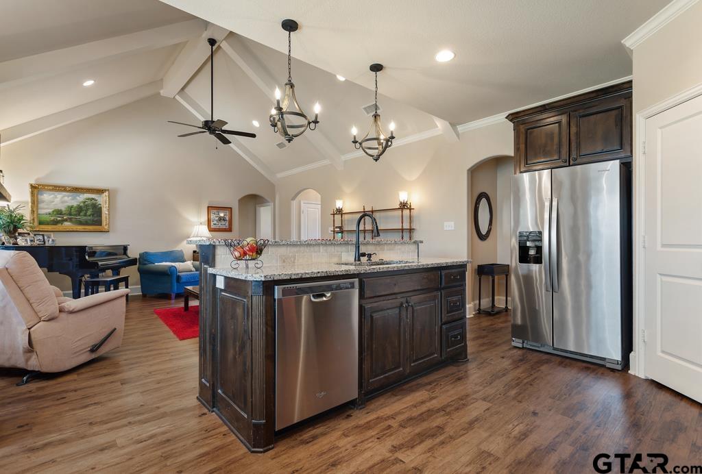 706 Duke Place Tyler, TX 75704 - Photo 11 of 33 a large kitchen with stainless steel appliances granite countertop a refrigerator a sink dishwasher a dining table and chairs with wooden floor