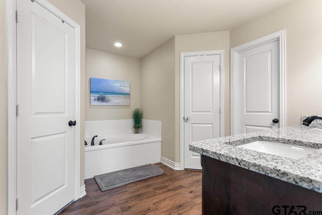 706 Duke Place Tyler, TX 75704 - Photo 14 of 33 a bathroom with a granite countertop sink and a bathtub