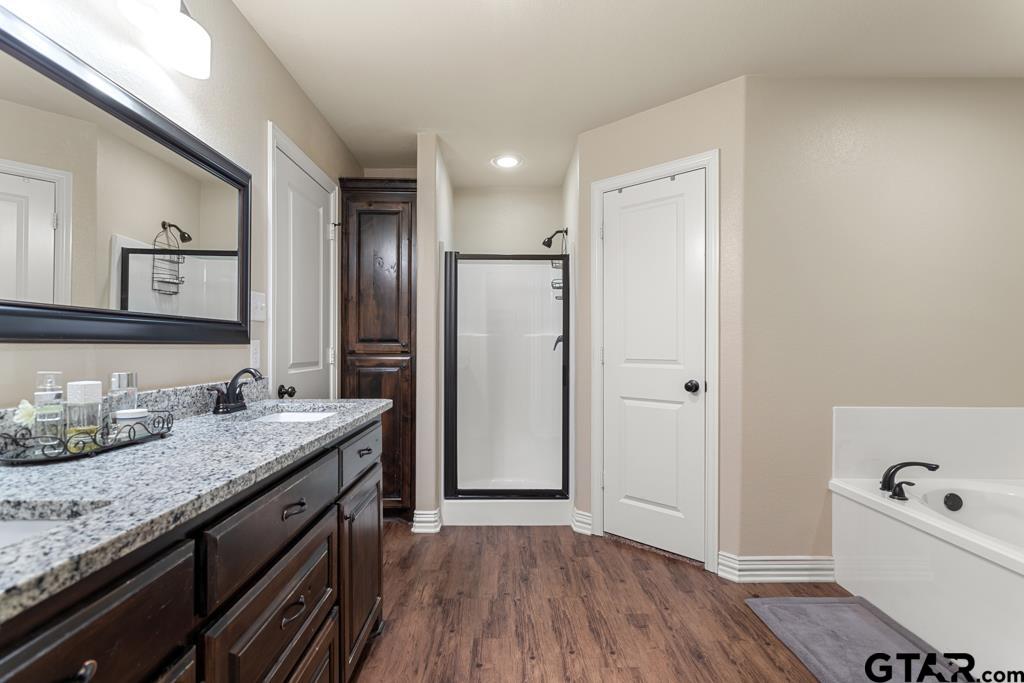 706 Duke Place Tyler, TX 75704 - Photo 15 of 33 a bathroom with a granite countertop sink a large mirror and a bathtub