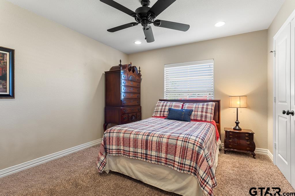 706 Duke Place Tyler, TX 75704 - Photo 19 of 33 a bedroom with a bed a dresser and a chandelier