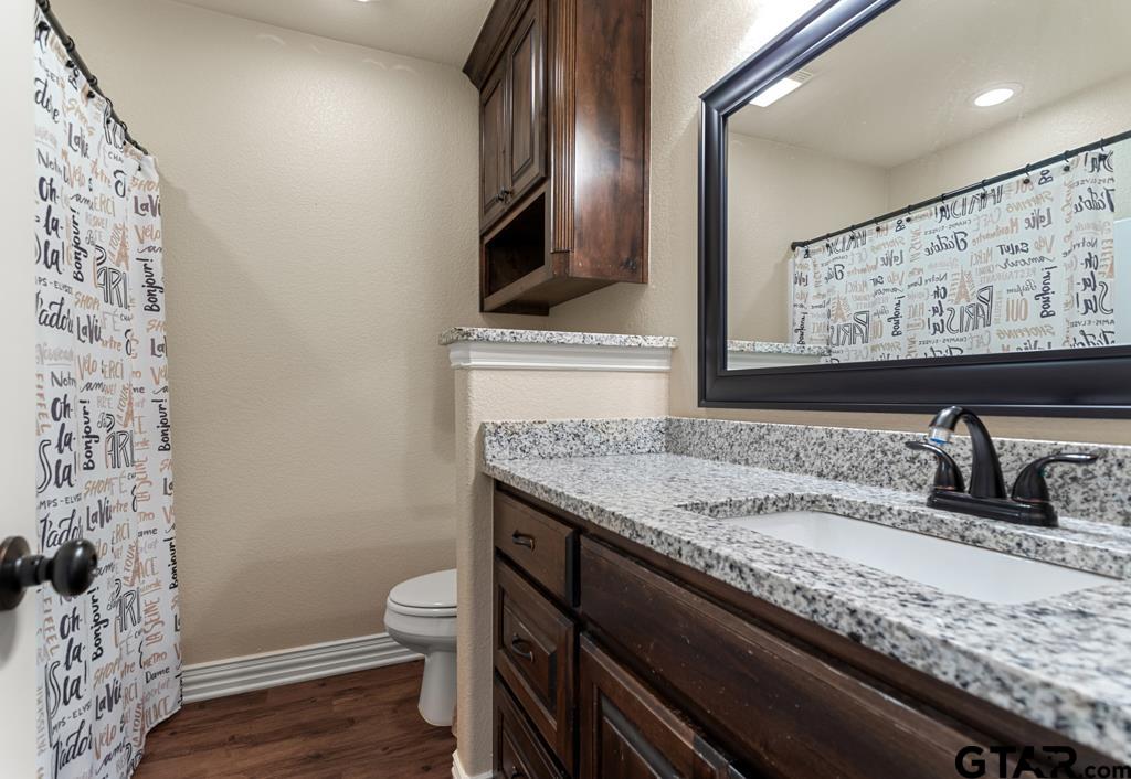 706 Duke Place Tyler, TX 75704 - Photo 21 of 33 a bathroom with a granite countertop toilet sink and mirror