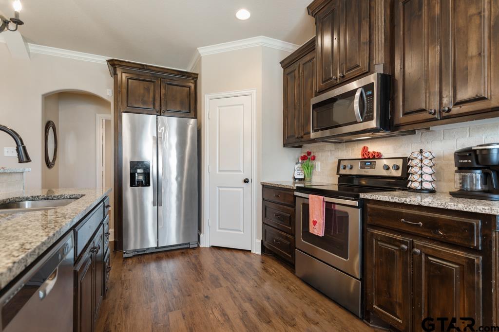706 Duke Place Tyler, TX 75704 - Photo 9 of 33 a kitchen with stainless steel appliances granite countertop a refrigerator microwave and sink
