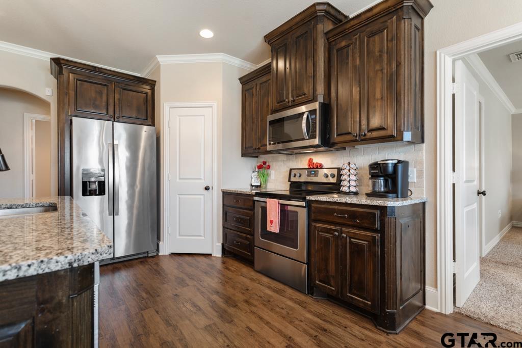 706 Duke Place Tyler, TX 75704 - Photo 10 of 33 a kitchen with stainless steel appliances granite countertop a refrigerator stove top oven and sink