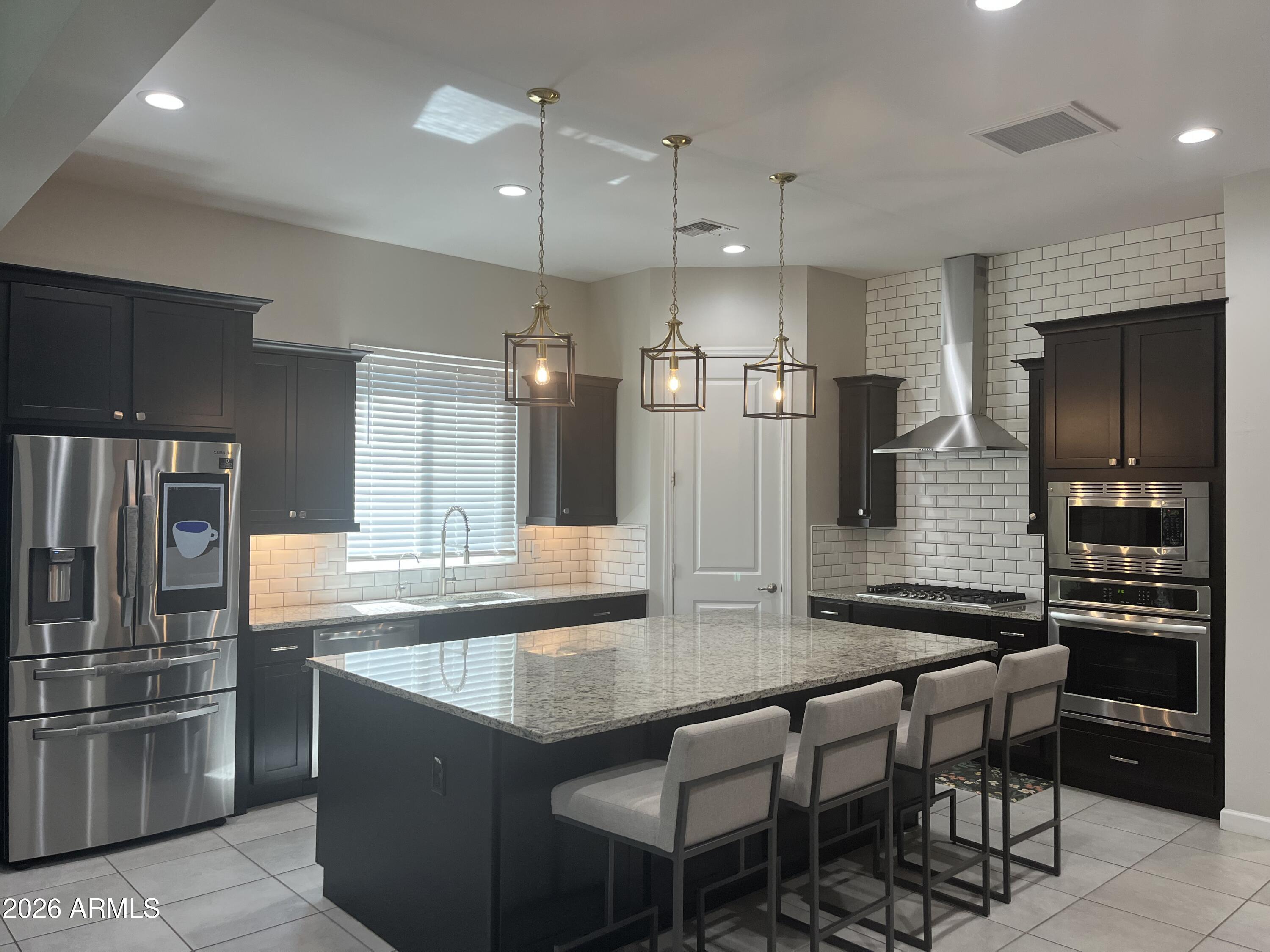 2141 East Alameda Road Phoenix, AZ 85024 - Photo 10 of 15 a kitchen with granite countertop a table chairs microwave and refrigerator