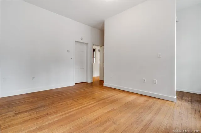 a view of an empty room with wooden floor